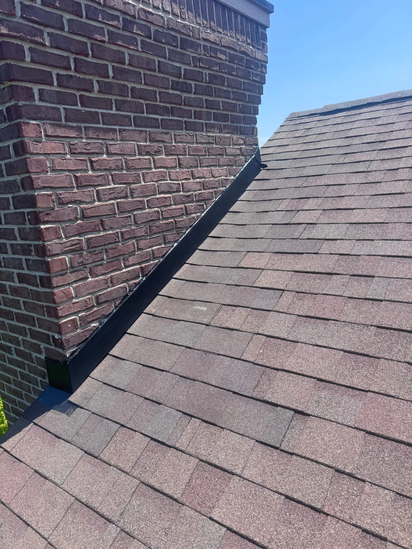 Completed chimney step flashing, counterflashing and matching shingle repair on Fishers home