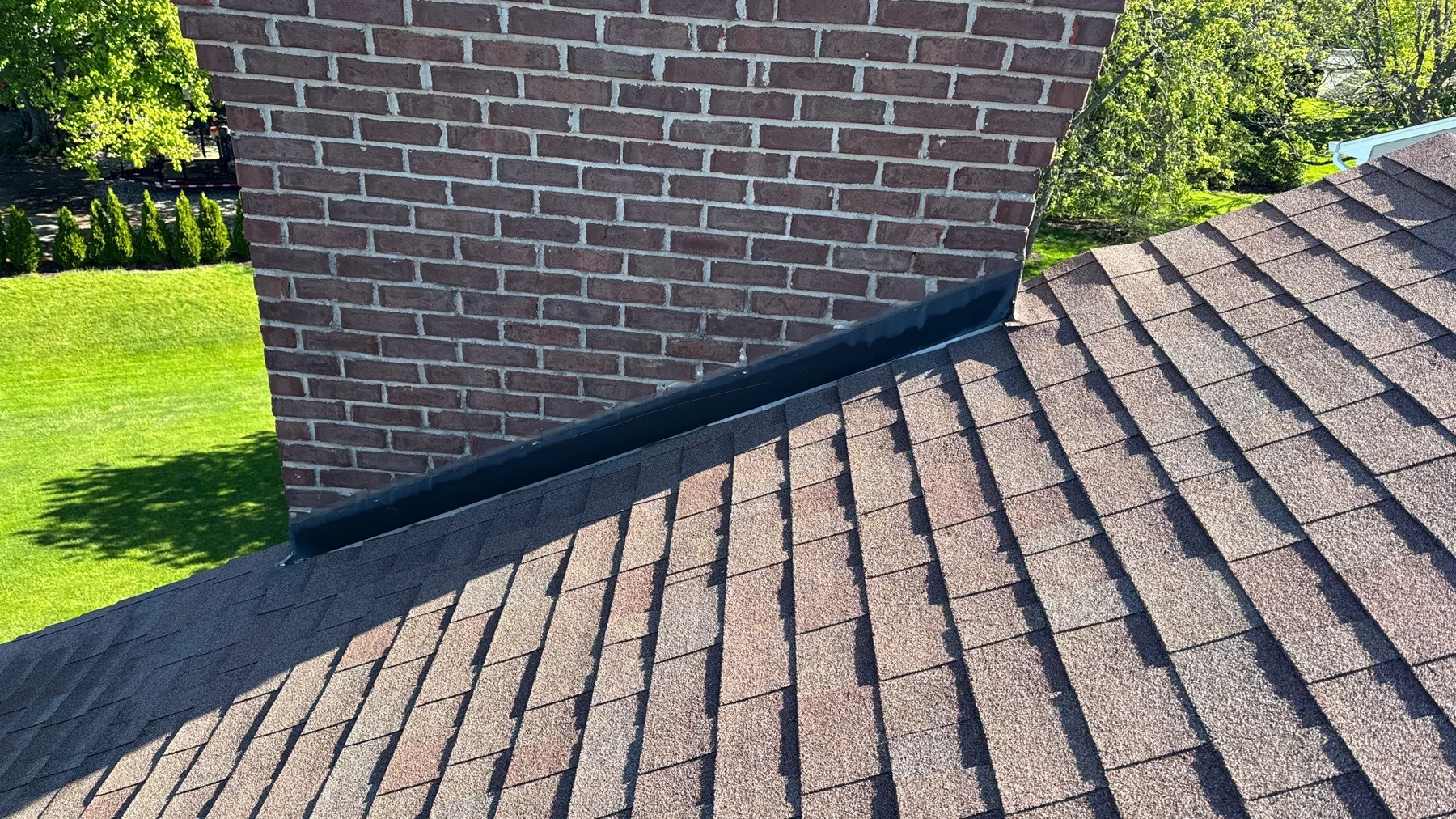 Chimney-area roof leak condition before localized flashing repair on Fishers home